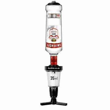 A Smirnoff vodka dispenser bottle turned upside down on a black tripod stand with a 35ml measuring cup attached below. The Smirnoff label is visible on the bottle, and 'BarBits.