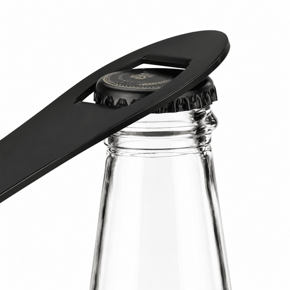 A black bar blade bottle opener tool resting on a clear glass bottle against a white background.