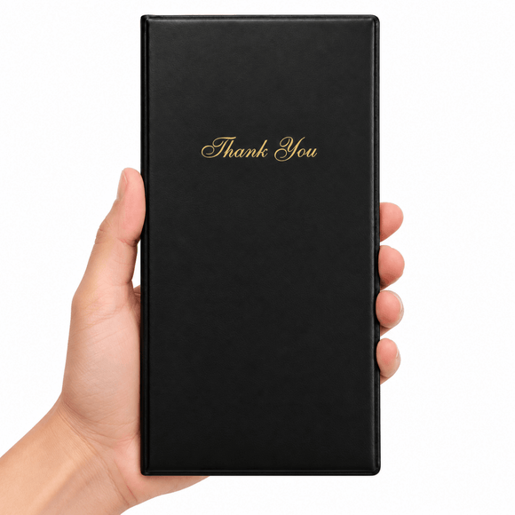 A hand holding a slim black rectangular bill presenter with elegant gold 'Thank You' script on the front, set against a plain white background.