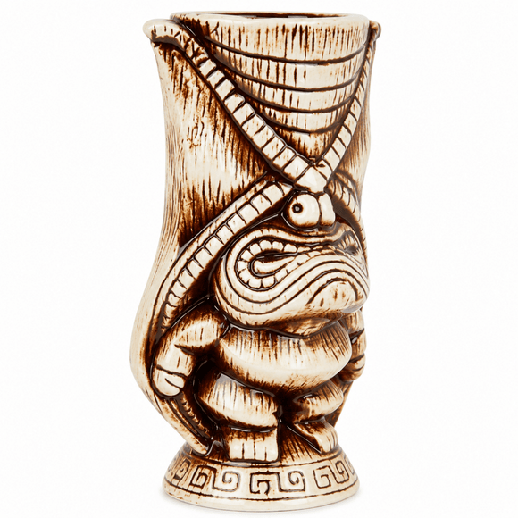 A carved ceramic tiki mug featuring a stylized frog design with crossed arms, detailed with dark brown burn marks on a cream-colored base, set against a plain white background.