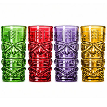 Four tiki-style tumblers in green, red, purple, and gold, arranged side by side on a plain white background.