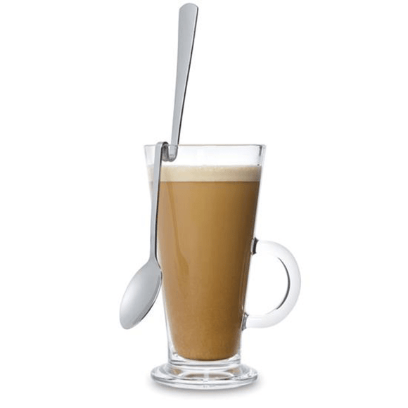 Clear glass mug with a handle filled with a creamy beverage, accompanied by a spoon on a white background.