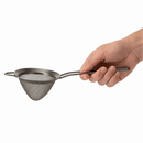 A hand holding a gunmetal stainless steel fine mesh strainer with a long handle against a plain white background.