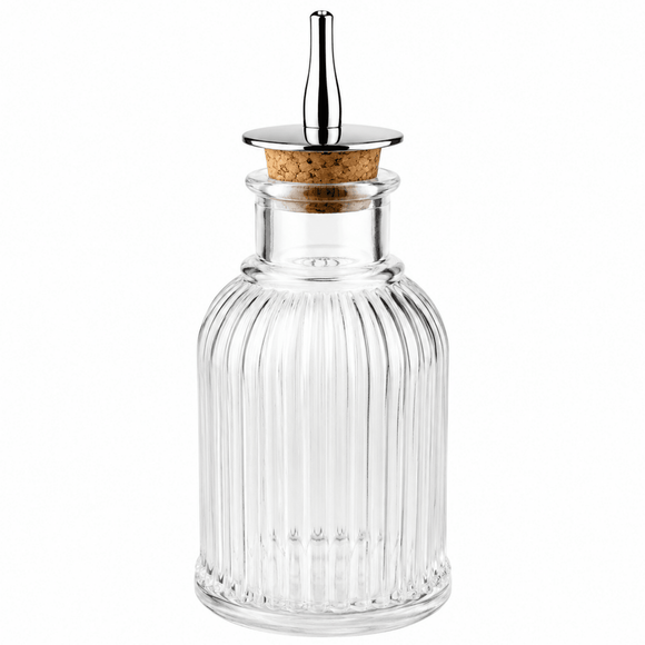 Clear glass Bitters bottle with a cork stopper on a white background