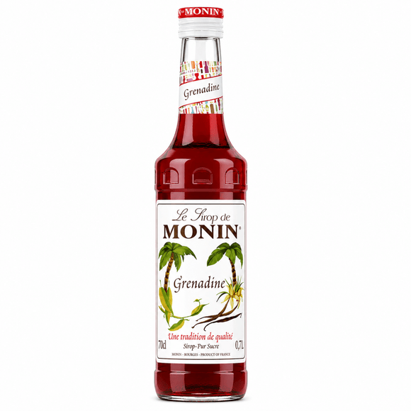 A bottle of Le Throp de MONIN Grenadine syrup, featuring a white label with green palm tree illustrations and a red cap, set against a plain white background.