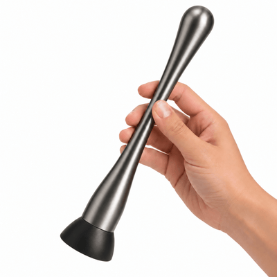 A hand holding stainless steel gunmetal slim cocktail muddler 23cm a black rubber base against a plain white background.