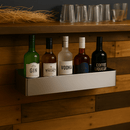 Stainless steel bottle rack in use on a bar counter with bottle in