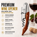 A premium wine opener tool with a stainless steel spiral corkscrew and wooden handle is shown on a light marble surface beside a glass of red wine, a cork, and promotional text highlighting features like effortless uncorking and a built-in bottle opener.